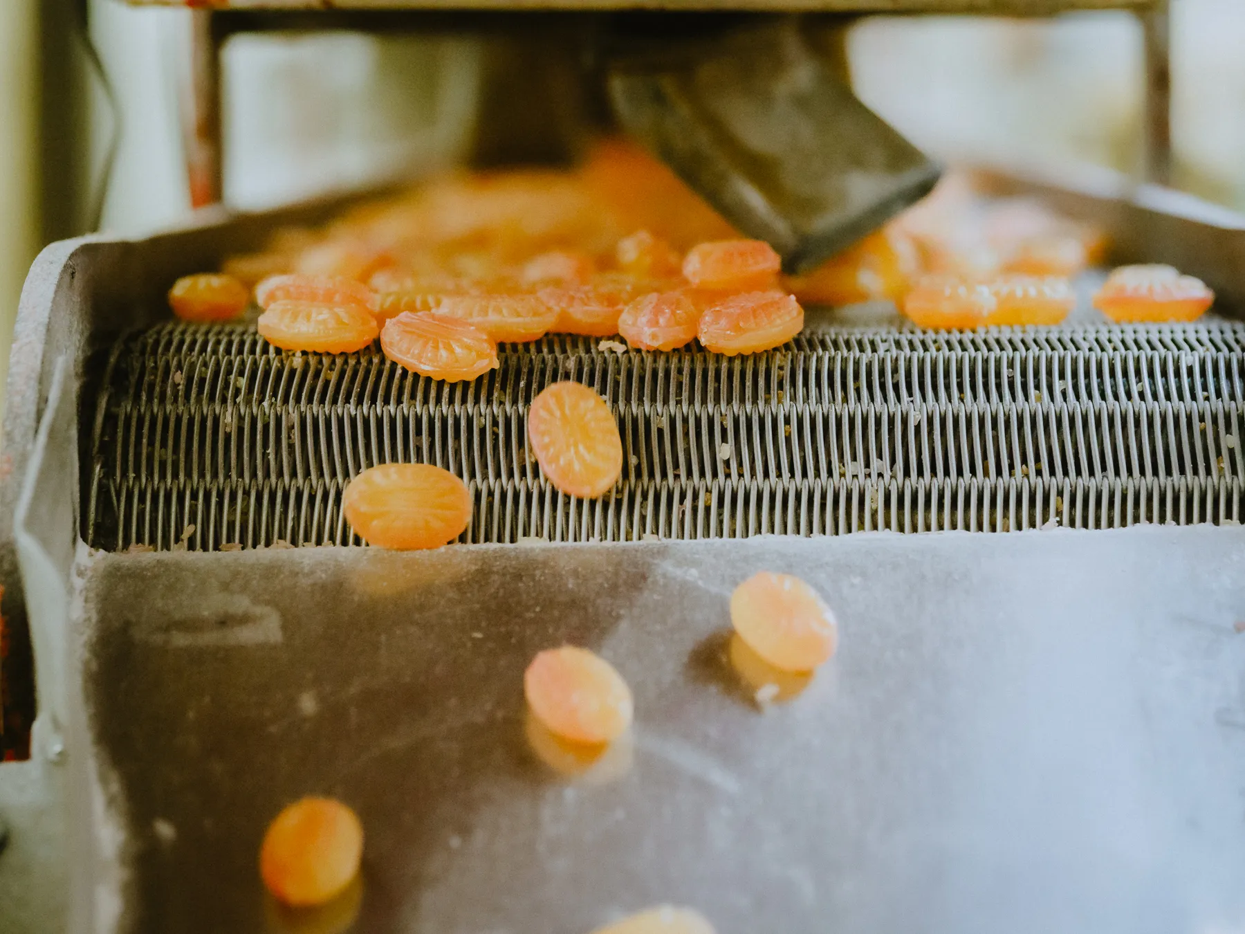 Frisch geprägte Bonbons auf dem Förderband — Produktion wie zu Kirmeszeiten